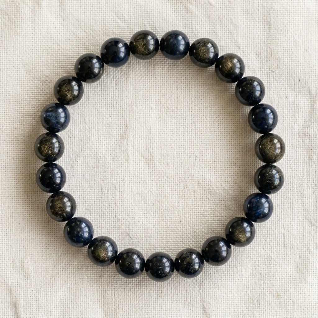 Bracelet en obsidienne dorée : perles rondes de pierre naturelle de 8 mm sur elastique, sans interperle (variante temporaire), vu de dessus sur du lin ivoire - visuel provisoire