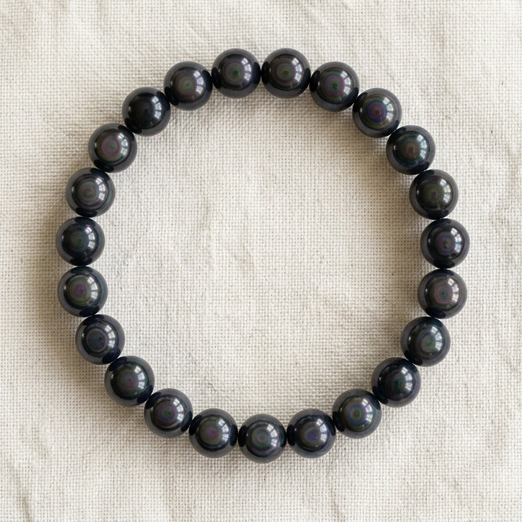 Bracelet en obsidienne œil céleste : perles rondes de pierre naturelle de 8 mm sur elastique, sans interperle (variante temporaire), vu de dessus sur du lin ivoire - visuel provisoire
