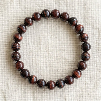 Bracelet en œil de taureau : perles rondes de pierre naturelle de 8 mm sur elastique, sans interperle (variante temporaire), vu de dessus sur du lin ivoire - visuel provisoire