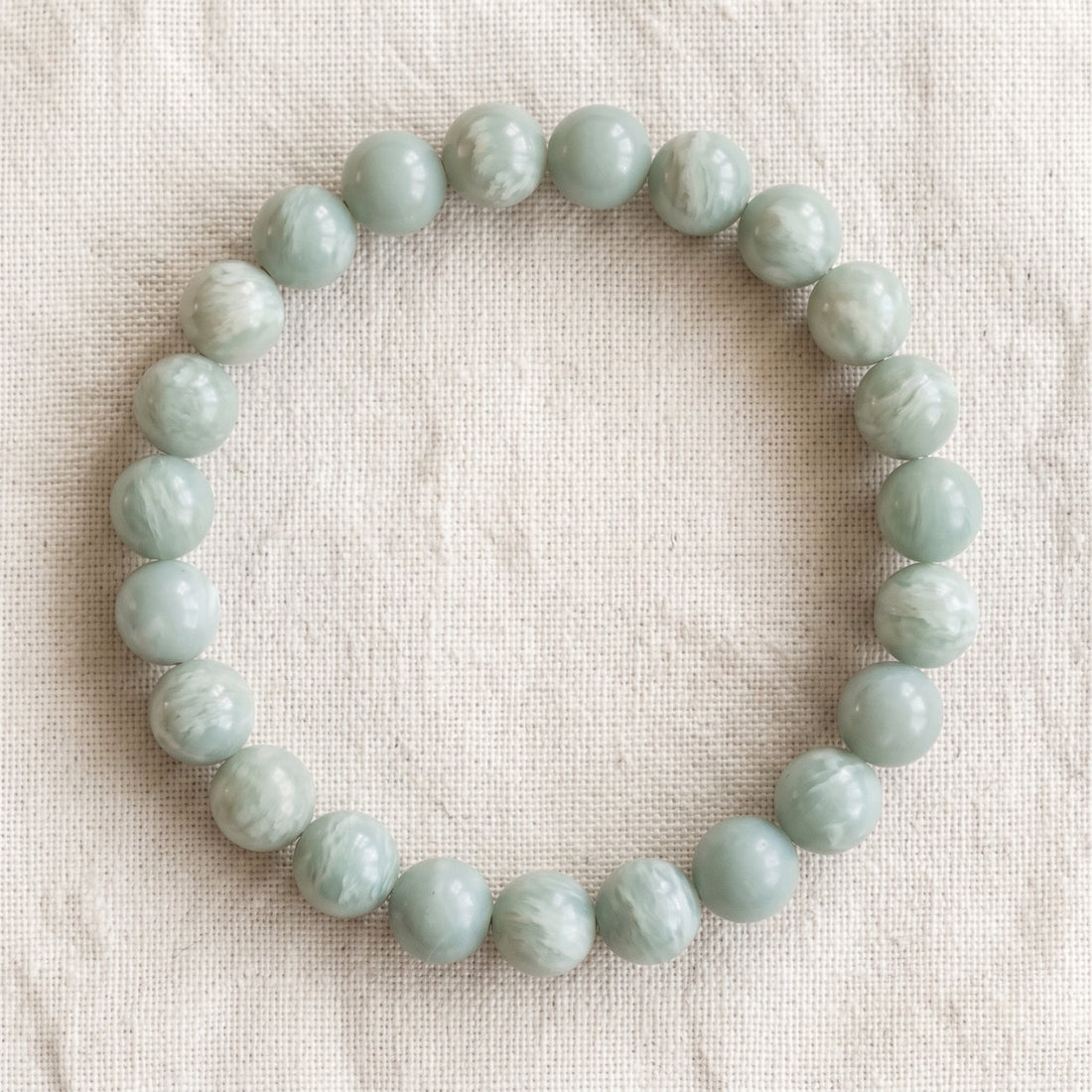 Bracelet en angélite verte : perles rondes de pierre naturelle de 8 mm sur élastique, sans interperle (variante temporaire), vu de dessus sur du lin ivoire - visuel provisoire