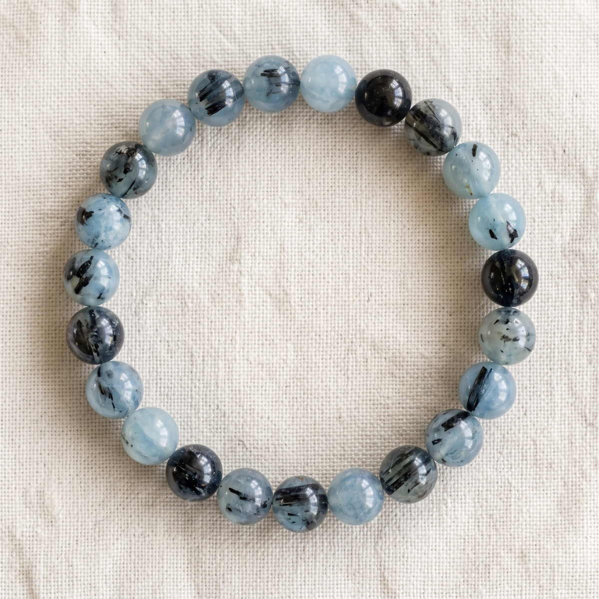 Bracelet en aigue marine tourmaline : perles rondes de pierre naturelle de 8 mm sur elastique, sans interperle (variante temporaire), vu de dessus sur du lin ivoire - visuel provisoire