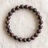 Bracelet en eudialyte : perles rondes de pierre naturelle de 8 mm sur elastique, sans interperle (variante temporaire), vu de dessus sur du lin ivoire - visuel provisoire