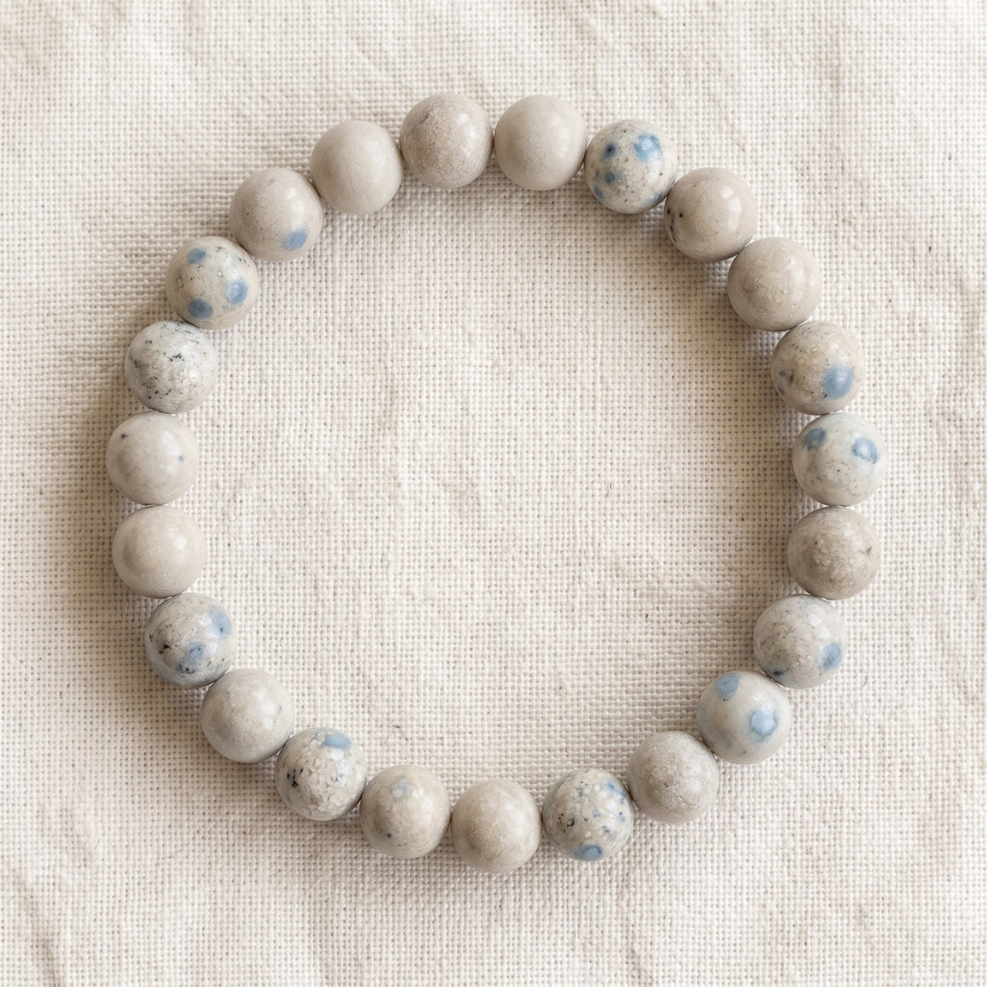 Bracelet en jaspe K2 : perles rondes de pierre naturelle de 8 mm sur elastique, sans interperle (variante temporaire), vu de dessus sur du lin ivoire - visuel provisoire