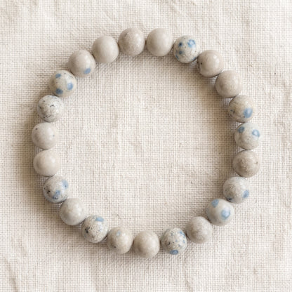 Bracelet en jaspe K2 : perles rondes de pierre naturelle de 8 mm sur elastique, sans interperle (variante temporaire), vu de dessus sur du lin ivoire - visuel provisoire
