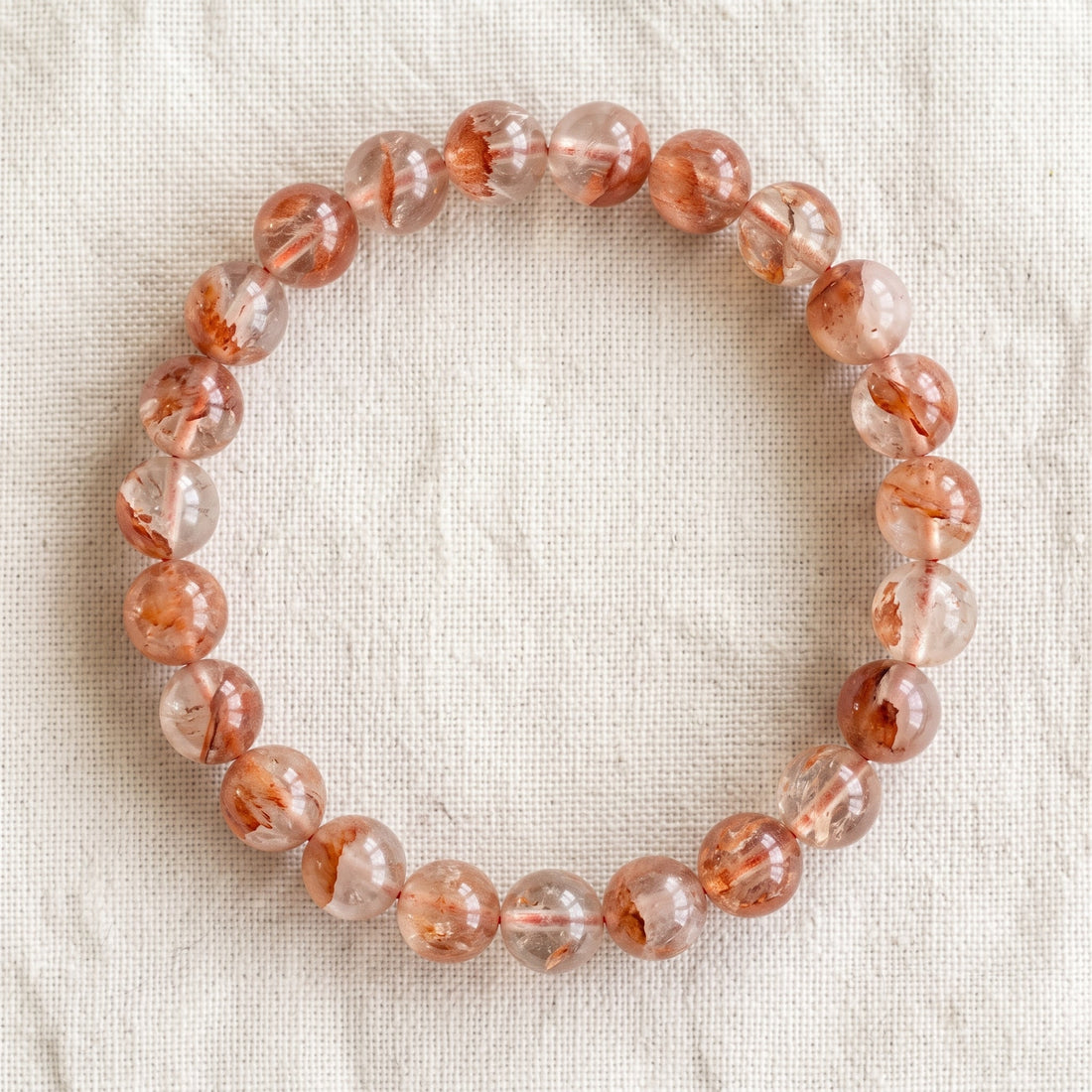 Bracelet en quartz hematoide : perles rondes de pierre naturelle de 8 mm sur elastique, sans interperle (variante temporaire), vu de dessus sur du lin ivoire - visuel provisoire