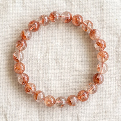 Bracelet en quartz hematoide : perles rondes de pierre naturelle de 8 mm sur elastique, sans interperle (variante temporaire), vu de dessus sur du lin ivoire - visuel provisoire