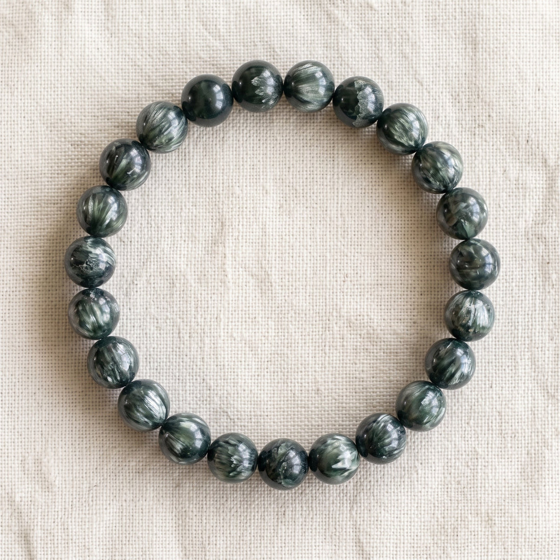 Bracelet en séraphinite : perles rondes de pierre naturelle de 8 mm sur elastique, sans interperle (variante temporaire), vu de dessus sur du lin ivoire - visuel provisoire
