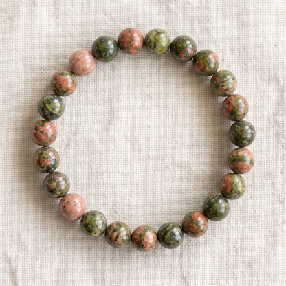 Bracelet en unakite : perles rondes de pierre naturelle de 8 mm sur elastique, sans interperle (variante temporaire), vu de dessus sur du lin ivoire - visuel provisoire